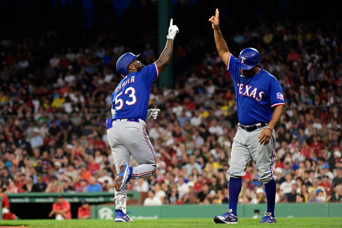 Texas Rangers right fielder Adolis Garcia, left, celebrates his two-run home run against the Boston Red Sox during the sixth inning at Fenway Park with third-base coach Tony Beasley.